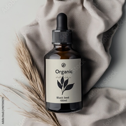 A minimalistic image of an organic black seed oil bottle with a simple label design, placed next to soft fabric and dried wheat on a neutral background - AI Generated Digital Art. photo