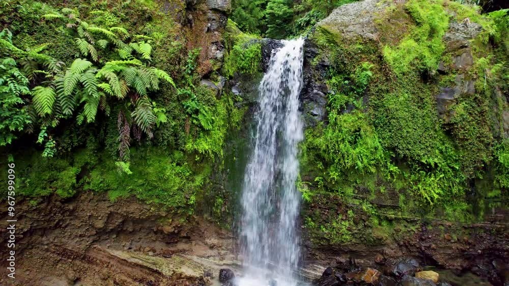 Aerial view of a breathtaking waterfall cascading through lush greenery and rocks in Parque Grena, Sao Miguel, Portugal. Aerial view of a breathtaking waterfall cascading through lush greenery and rocks in Parque Grena, Sao Miguel, Portugal.