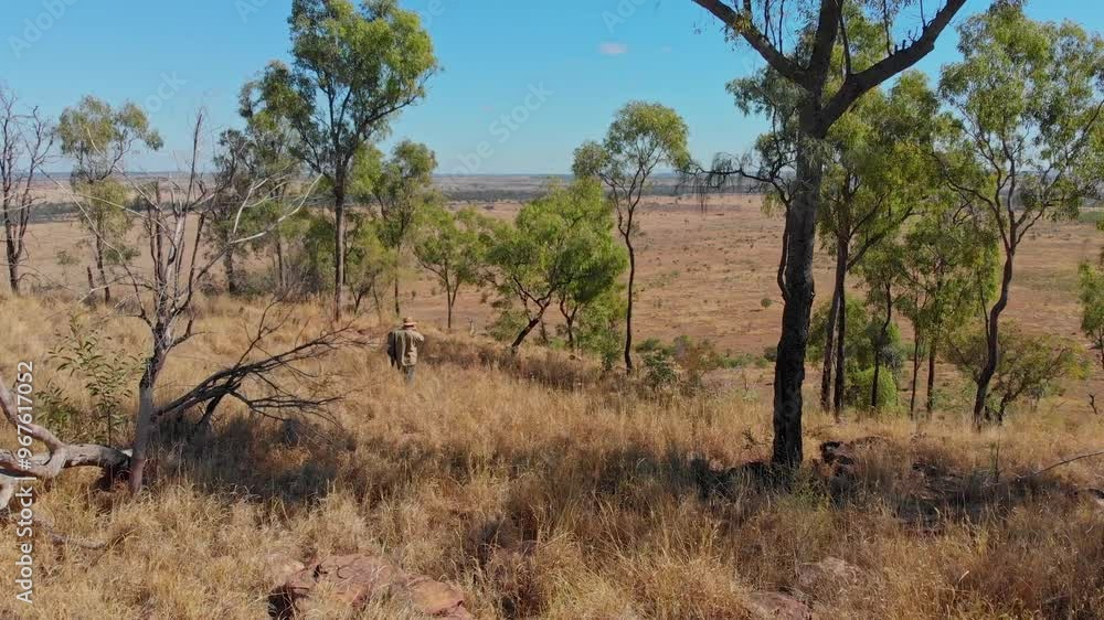 Aerial view of dry outback landscape with man farming among trees and grassland, Mackenzie River, Queensland, Australia. Aerial view of dry outback landscape with man farming among trees and grassland, Mackenzie River, Queensland, Australia.