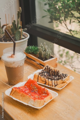 Wooden table with drinks and a plate of sliced watermelon by a window photo