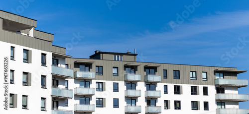 Obraz na płótnie White and beige facade of a newly built apartment block. Clear blue sky above the building. Photo taken on a sunny day w salonie