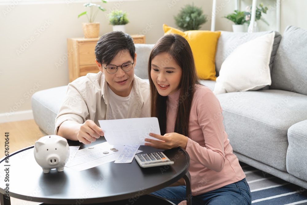 Happy asian family young couple love hand holding piggy bank to save and model house for saving money wealth to buy real estate for new home. Financial planning, business finance concept. Housing loan Happy asian family young couple love hand holding piggy bank to save and model house for saving money wealth to buy real estate for new home. Financial planning, business finance concept. Housing loan