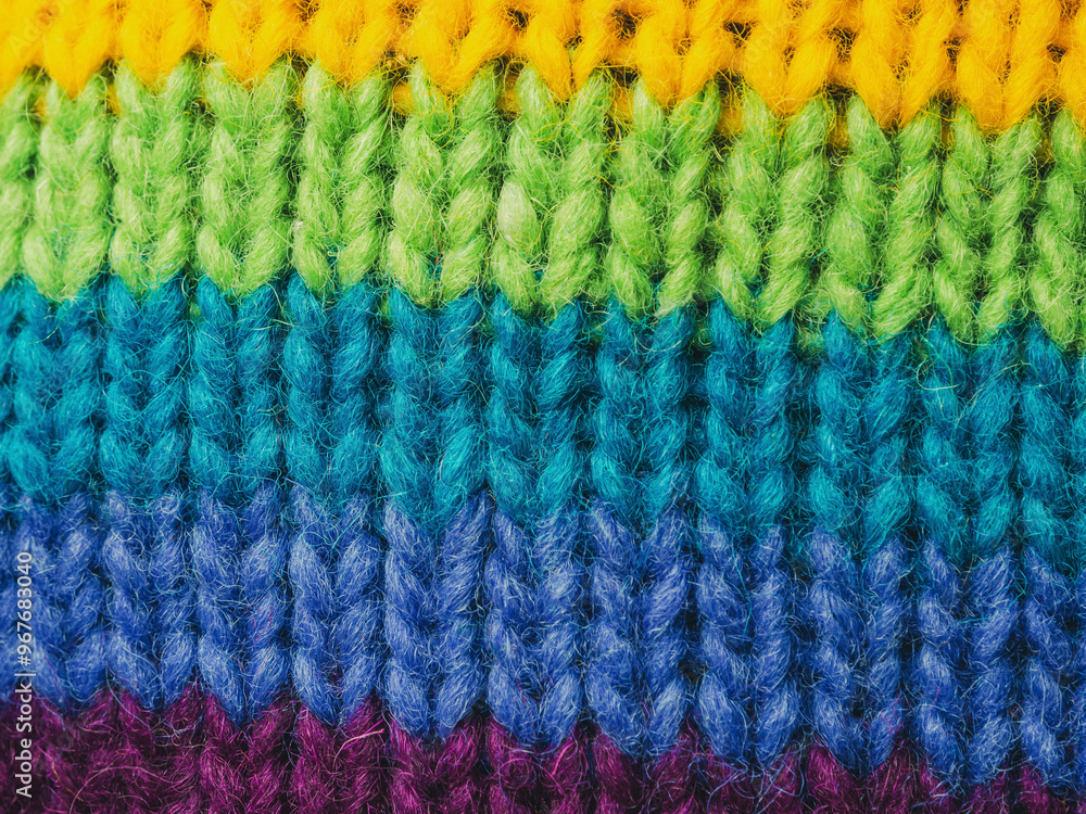 Close-up of bright multi-colored knitted wool fabric. Detailed textures and rich colors highlight the quality and appeal Close-up of bright multi-colored knitted wool fabric. Detailed textures and rich colors highlight the quality and appeal