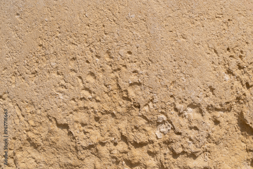 Rough textured beige stone surface with irregular bumps and natural imperfections. Backgrounds Rough textured beige stone surface with irregular bumps and natural imperfections. Backgrounds