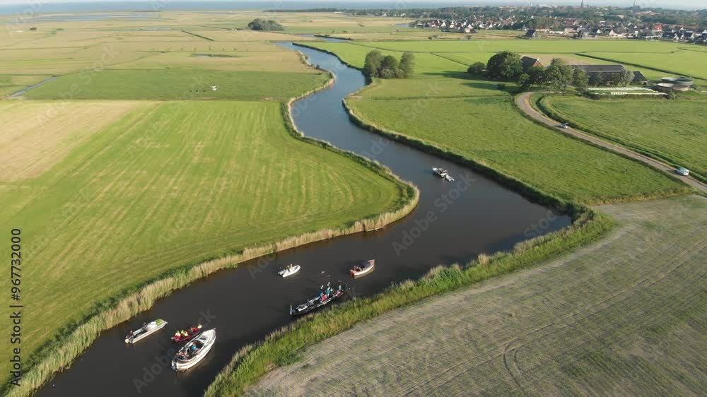 Aerial view of serene river with boats and picturesque fields in summer, Arum, Netherlands.