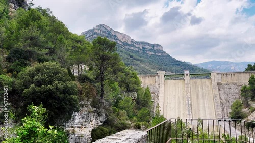 A reservoir with azure water in the mountains of Spain, a trail near Montanejos, Castellon. A dam covers the river for safety during heavy rains. A popular place for active recreation. The Arenos photo