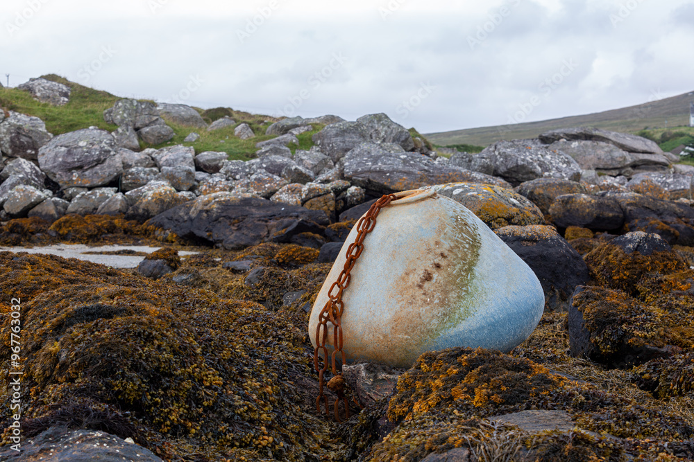 Buoy and chain resting on the rocks at low tide, Image shows a large blue buoy and chain resting on the sea bed during low tide on a remote Scottish island Buoy and chain resting on the rocks at low tide, Image shows a large blue buoy and chain resting on the sea bed during low tide on a remote Scottish island