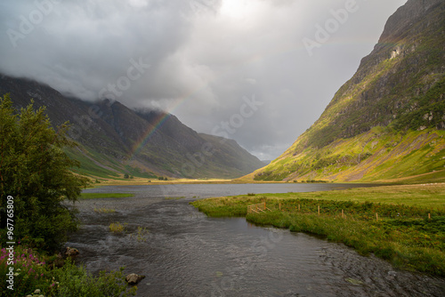 Loch Achtriochtan with a rainbow, Image shows the loch during a storm resulting in a rainbow across the water and dark clouds covering the sky and mountain peaks photo