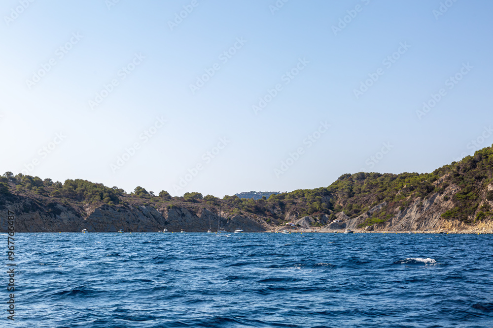 Coastal landscape image of the cliffs along the Spanish coastline from a boat, Image shows a beautiful scenic photo of the cliffs with blue skies and blue sea Coastal landscape image of the cliffs along the Spanish coastline from a boat, Image shows a beautiful scenic photo of the cliffs with blue skies and blue sea