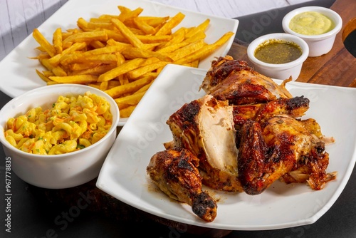 Deliciously charred and smoky Pollo a la Brasa (grilled chicken) served whole and in pieces, accompanied by crispy fries, fresh salad, and a flavorful dipping sauce. A classic Latin American dish, coo photo