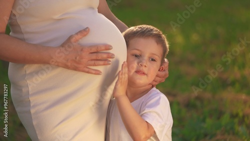 a son pregnant mother. little boy hugs his pregnant mom belly. son pregnant mom happy family kid dream concept.woman experiences motherhood for second time, boy will become the older brother lifestyle photo