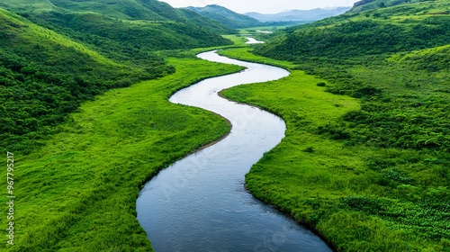 A serene river winding through lush green hills under a clear sky, perfect for nature lovers and outdoor enthusiasts.