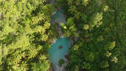 Aerial view of beautiful Cambugahay Falls with a bamboo raft and a woman at sunrise, Lazi, Philippines. photo