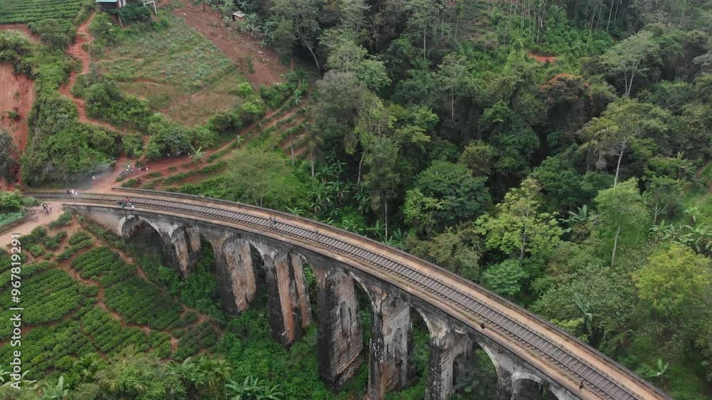Aerial view of the iconic nine arches bridge surrounded by lush tea fields and jungle, Ella, Sri Lanka. Aerial view of the iconic nine arches bridge surrounded by lush tea fields and jungle, Ella, Sri Lanka.