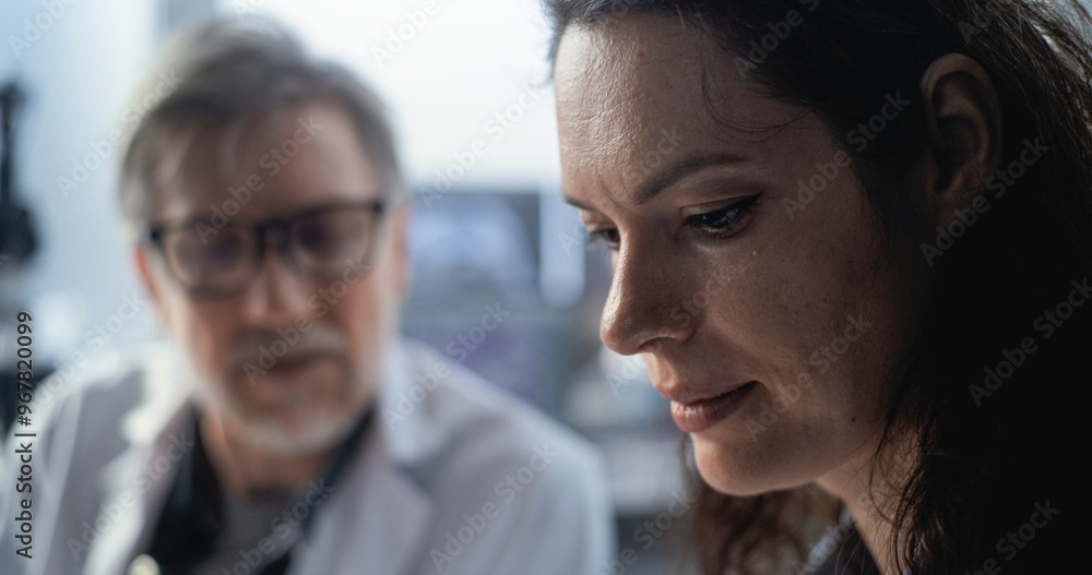 Portrait of mature scientist discussing historical or scientific research with female colleague. Paleontologists or microbiologists work in advanced archaeological lab. Science concept. Close Up. Portrait of mature scientist discussing historical or scientific research with female colleague. Paleontologists or microbiologists work in advanced archaeological lab. Science concept. Close Up.