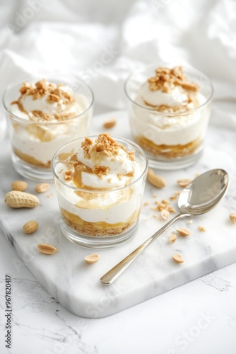 Three scoops of vanilla ice cream topped with pecans and whipped cream, served in clear glass bowls on a white surface.