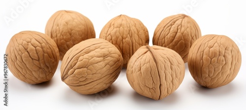 Brown walnuts arranged on a white background showcasing their textured shells and natural appearance