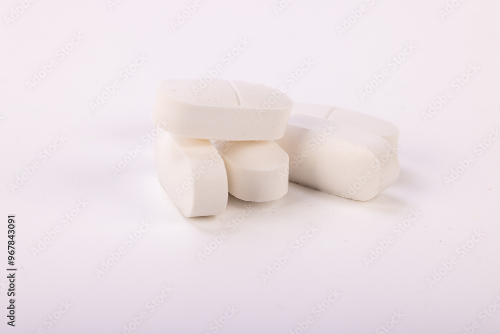High-detail image of white pills on a neutral white background, perfect for illustrating medical treatments High-detail image of white pills on a neutral white background, perfect for illustrating medical treatments