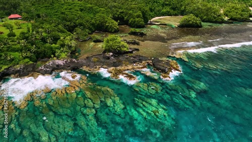 Aerial view of a tropical island with clear turquoise water and lush greenery, Atua, Samoa. photo