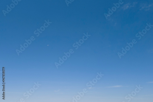 Clear blue sky with no clouds, showcasing a serene and uninterrupted horizon.