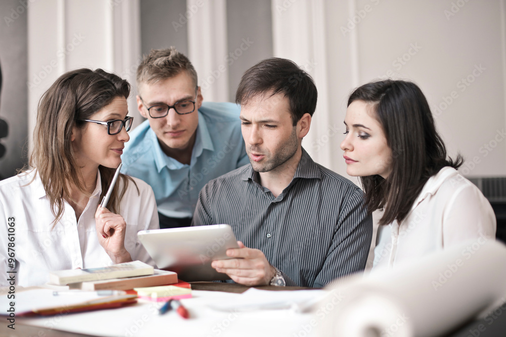 group of young people working in the office with a tablet