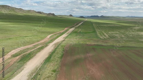 Aerial view of a breathtaking valley with a winding road and mountains under a vast sky, Iven Valley, Mongolia. photo