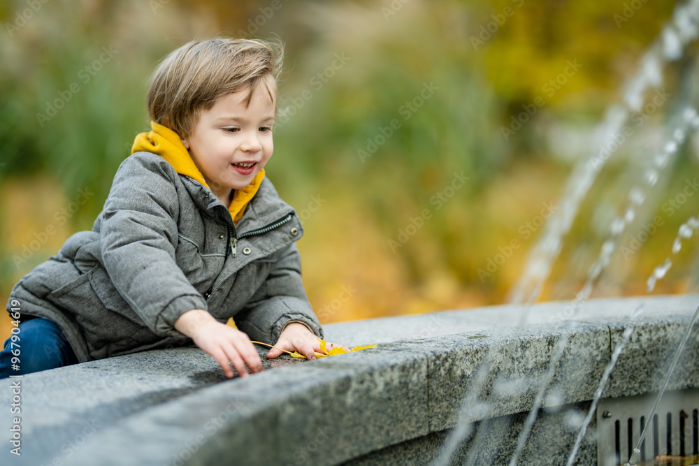 Cute little boy playing outdoors on sunny autumn day. Child exploring nature. Fall activities for kids. Cute little boy playing outdoors on sunny autumn day. Child exploring nature. Fall activities for kids.