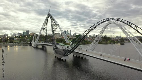 Aerial view of matagarup bridge over the river with a modern cityscape and overcast sky, perth, australia. photo