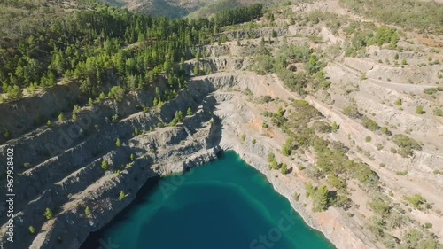 Aerial view of highbury quarry with serene blue lake surrounded by green forest and majestic mountains, adelaide, south australia. photo