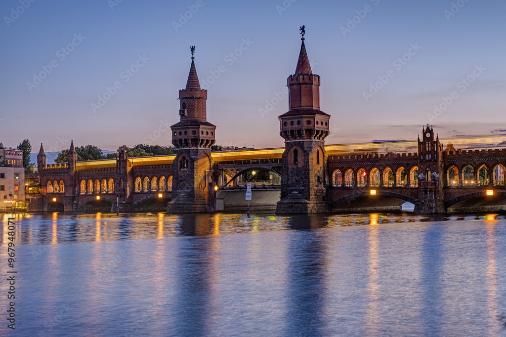 Naklejka premium The Oberbaumbruecke over the river Spree in Berlin after sunset with a motion blurred subway