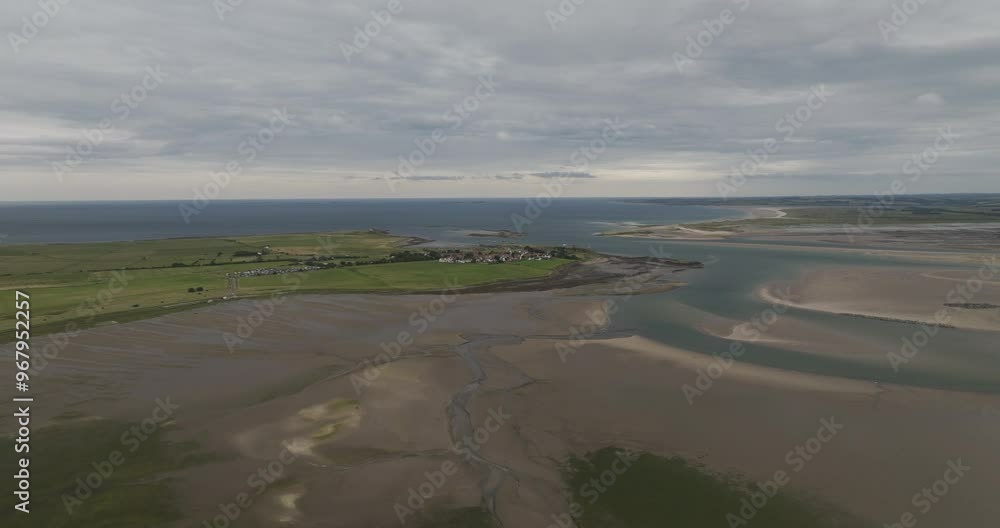 Aerial view of holy island at low tide with tranquil coastline and sandy tidal flats, Berwick-upon-Tweed, United Kingdom. Aerial view of holy island at low tide with tranquil coastline and sandy tidal flats, Berwick-upon-Tweed, United Kingdom.