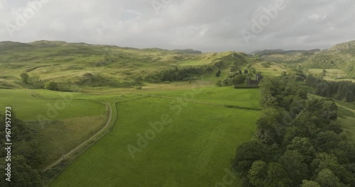 Aerial view of a serene castle surrounded by lush rolling hills and trees, Lochgilphead, Scotland. photo