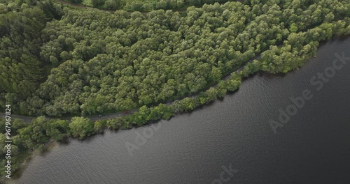 Aerial view of serene Loch Lomond surrounded by lush forests and a winding road, Arrochar, United Kingdom. photo