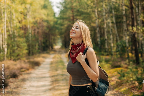 A young white woman tourist with a backpack in a pine forest in summer