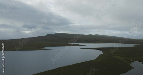 Aerial view of tranquil Loch Leathan surrounded by majestic hills under a cloudy sky, Portree, United Kingdom. photo