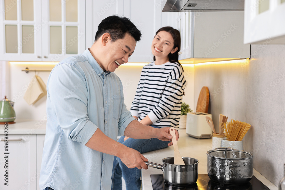 Happy lovely couple cooking together in kitchen Happy lovely couple cooking together in kitchen
