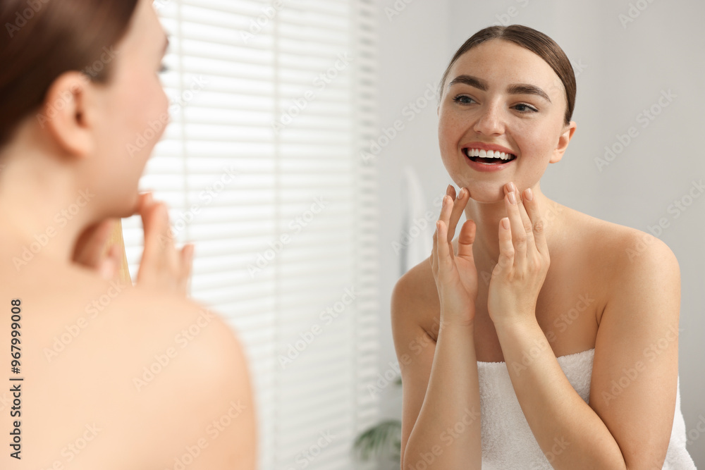 Face massage. Beautiful young woman with healthy skin near mirror at home Face massage. Beautiful young woman with healthy skin near mirror at home