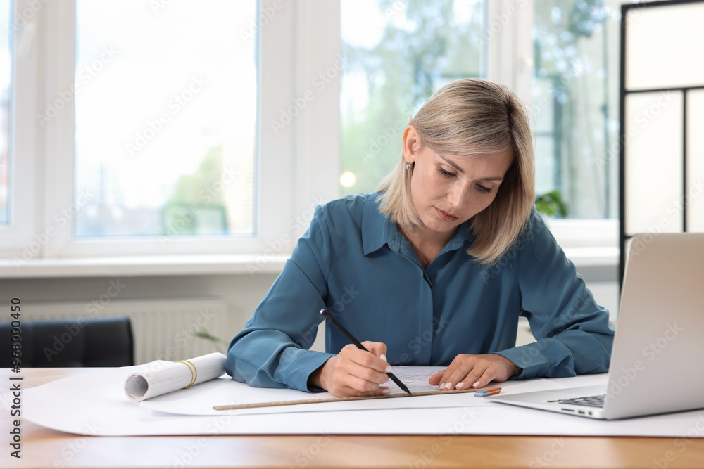 Architect making engineering drawing at table in office Architect making engineering drawing at table in office