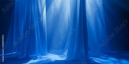 Soft blue silks drape gently while illuminated by mellow light, creating a tranquil atmosphere in an indoor setting at dawn photo