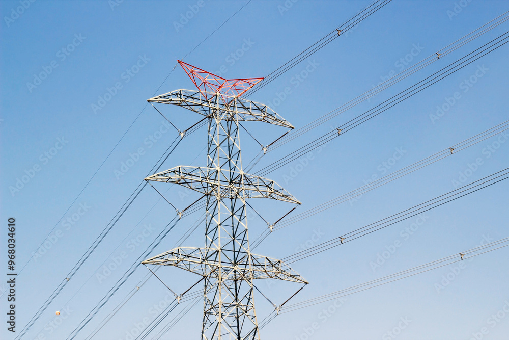 Close-up taken of a concrete electric pole with steel cables in blue sky Close-up taken of a concrete electric pole with steel cables in blue sky
