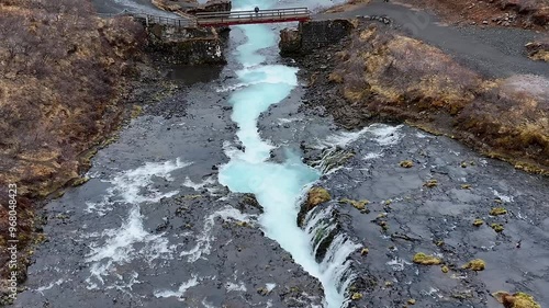 Aerial view of waterfall Bruararfoss surrounded by snow and ice in a tranquil landscape, Southern region, Iceland. photo