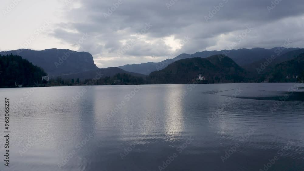 Aerial view of tranquil Bled Lake with Assumption of Maria Church surrounded by picturesque mountains, Bled, Slovenia.