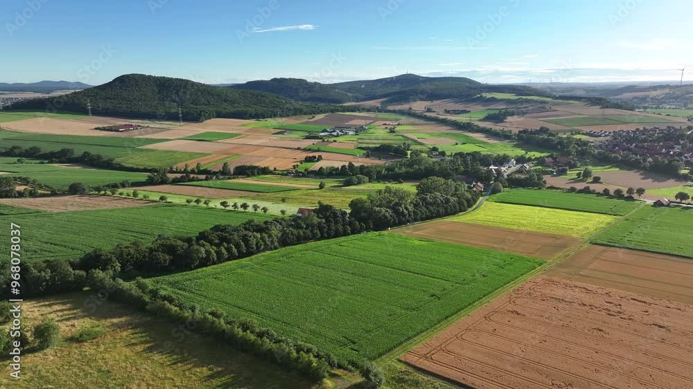 Aerial view of picturesque summer fields and a tranquil village in a lush valley, Humme, Hessia, Germany. Aerial view of picturesque summer fields and a tranquil village in a lush valley, Humme, Hessia, Germany.