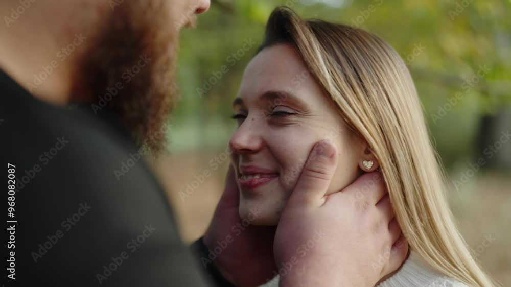 Close-up of a young woman smiling lovingly as her partner caresses her face gently, set against a blurred autumnal backdrop, symbolizing love and affection. Romantic Couple Enjoying A Tender Moment Close-up of a young woman smiling lovingly as her partner caresses her face gently, set against a blurred autumnal backdrop, symbolizing love and affection. Romantic Couple Enjoying A Tender Moment