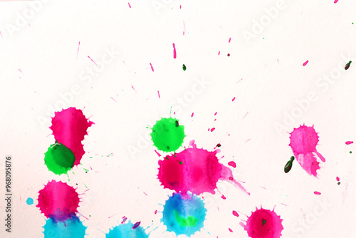 Various color paint drops on paper, causing dispersion of color.