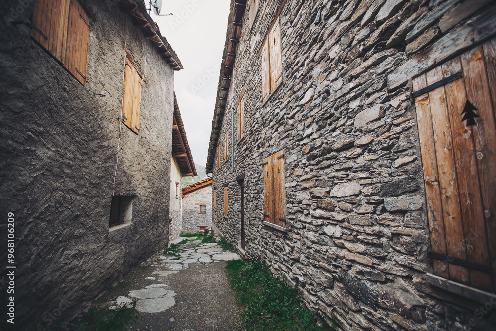 antique wooden window on a construction made of slate, typical of the villages of architecture in the province of Alps Mountains. Closed wooden window shutters with with typical alpine decoration antique wooden window on a construction made of slate, typical of the villages of architecture in the province of Alps Mountains. Closed wooden window shutters with with typical alpine decoration