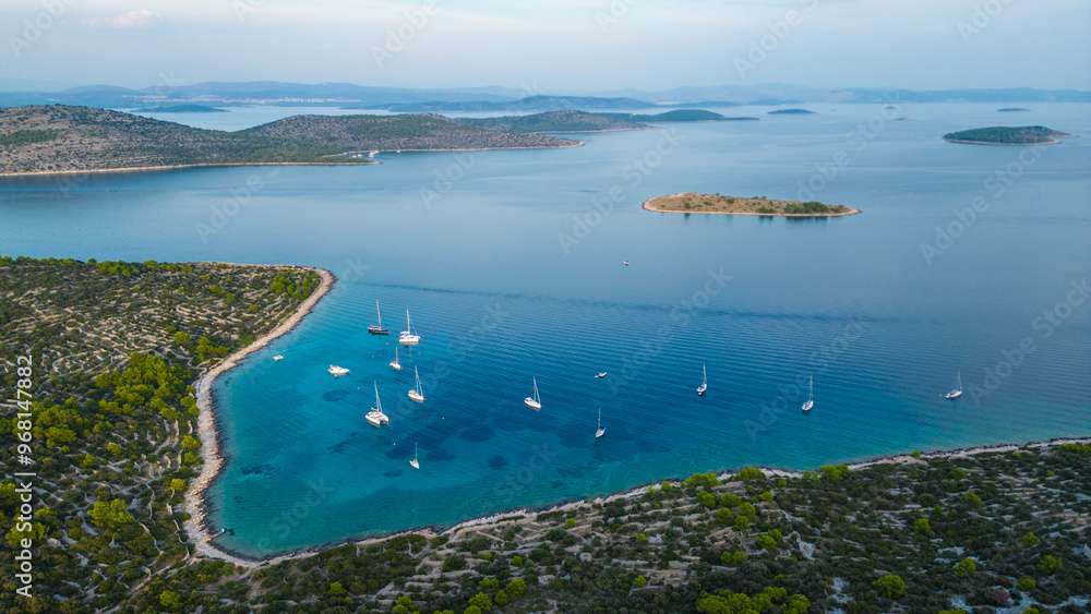 Obraz premium An aerial view of Vela Nozdra, a beautiful bay on the island of Kaprije, Croatia. This secluded spot, nestled between lush greenery and rocky shores, offers crystal-clear waters perfect for swimming