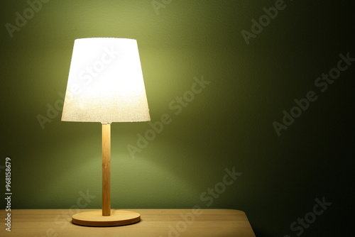 Glowing lamp on wooden tabl...
