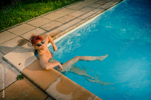 Femme prenant un bain dans une piscine en été photo