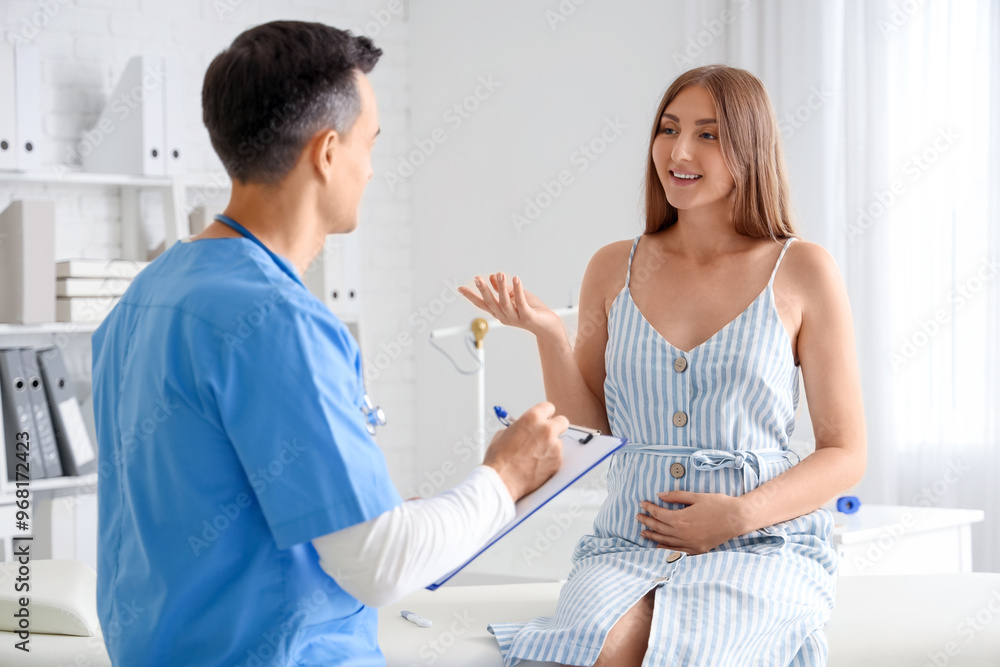 Fototapeta premium Young pregnant woman visiting doctor in clinic